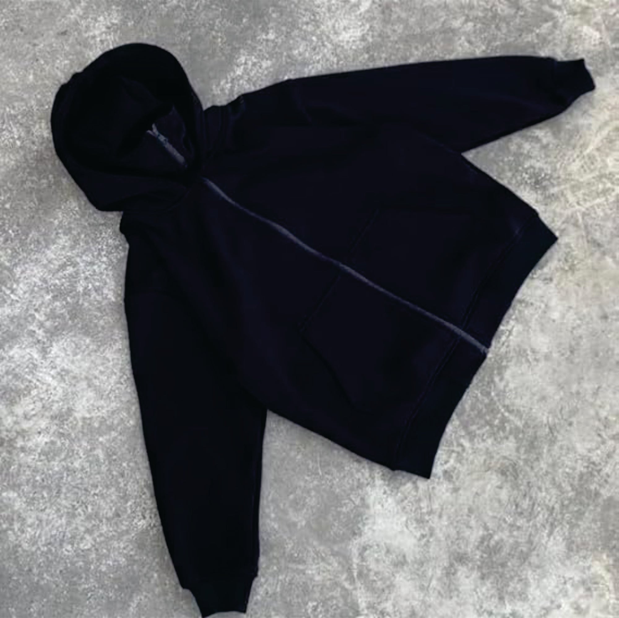 Black hoodie on a textured gray surface