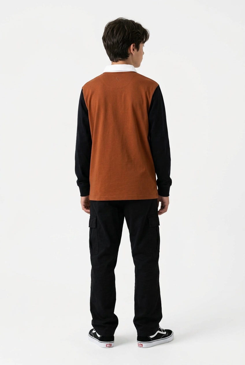 A long-sleeve rugby-style shirt shown from the back, featuring a rust-orange body, dark navy sleeves, and a white collar, laid flat against a white background.