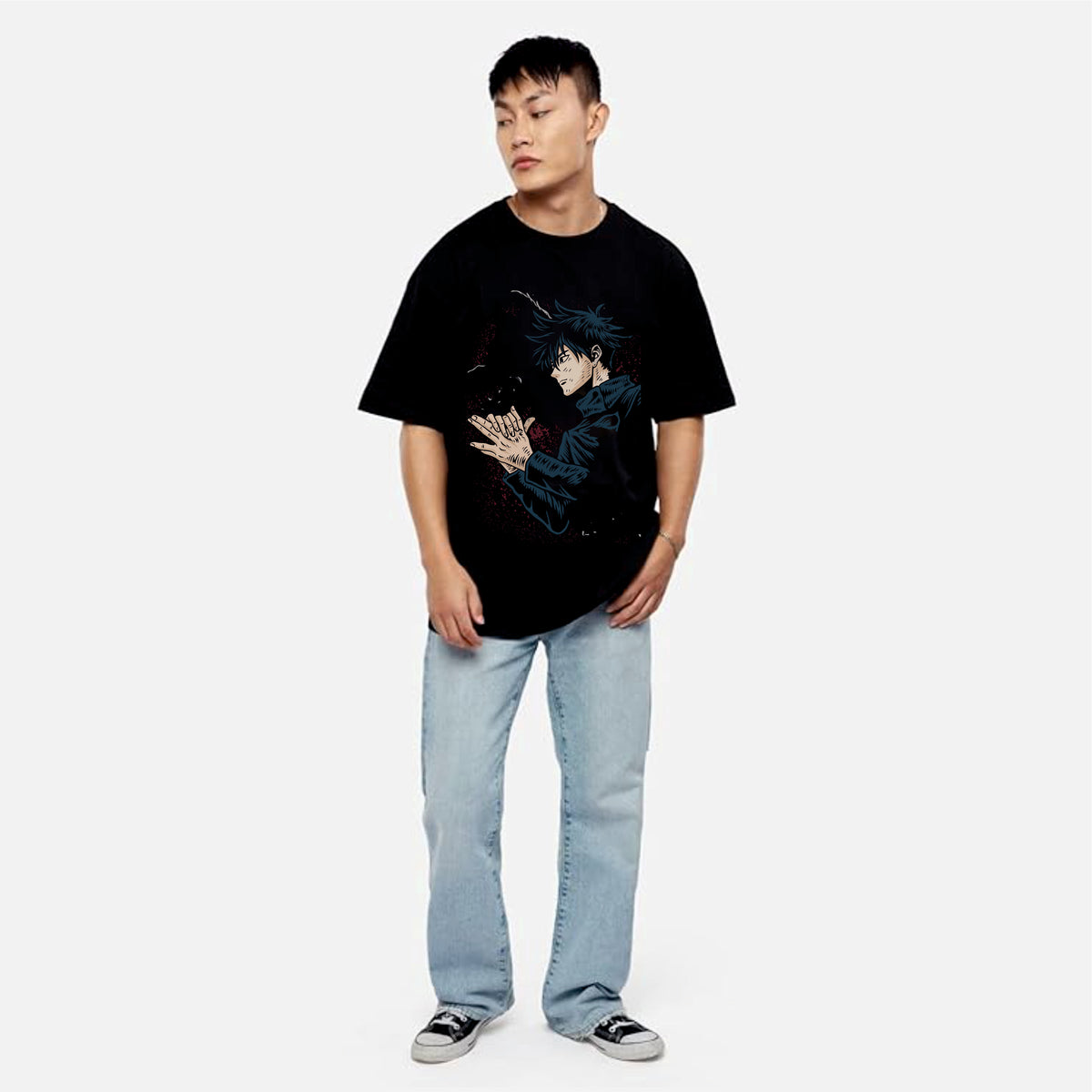 Person wearing a black t-shirt with a graphic design and light blue jeans