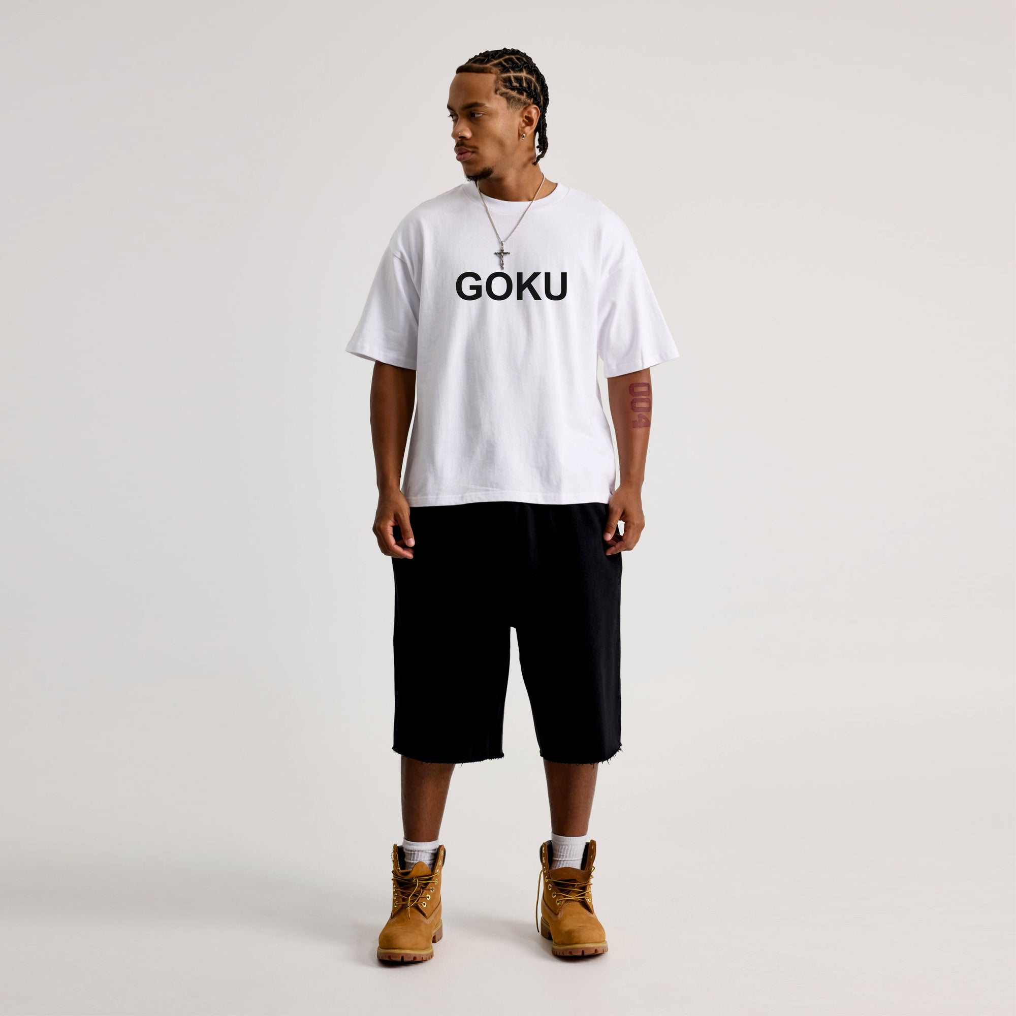 Person wearing a white t-shirt with 'GOKU' text on a plain background