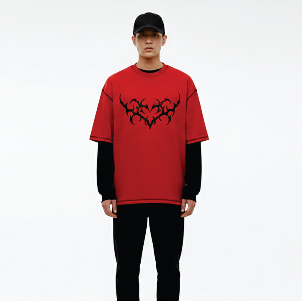 Person wearing a red t-shirt with black tribal design on a white background