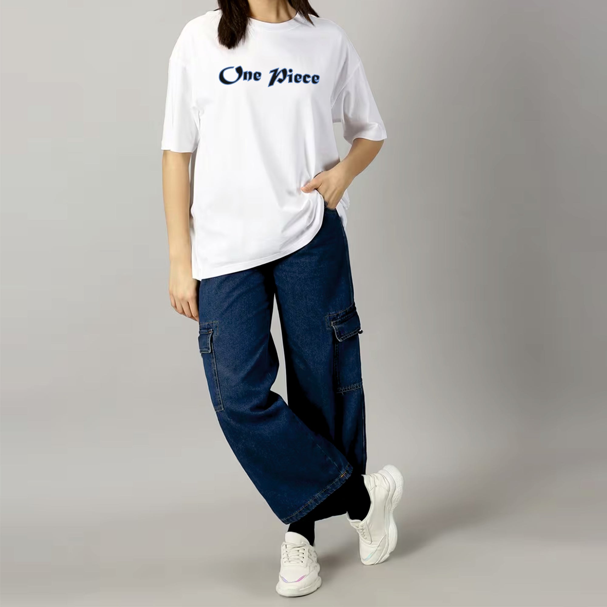 Person wearing a white 'One Piece' t-shirt, blue jeans, and white sneakers on a gray background