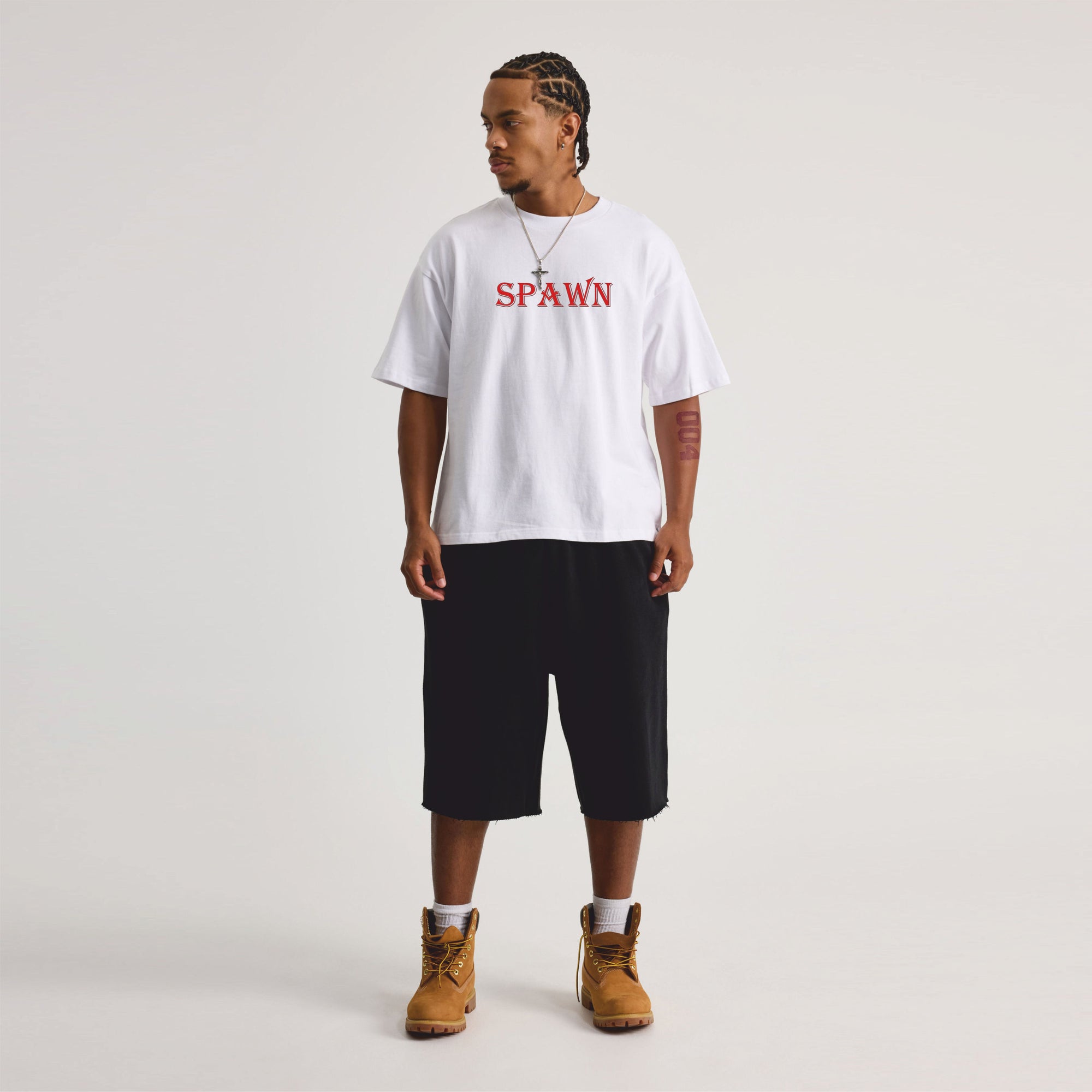 Person wearing a white t-shirt with 'SPAWN' printed in red on a plain background