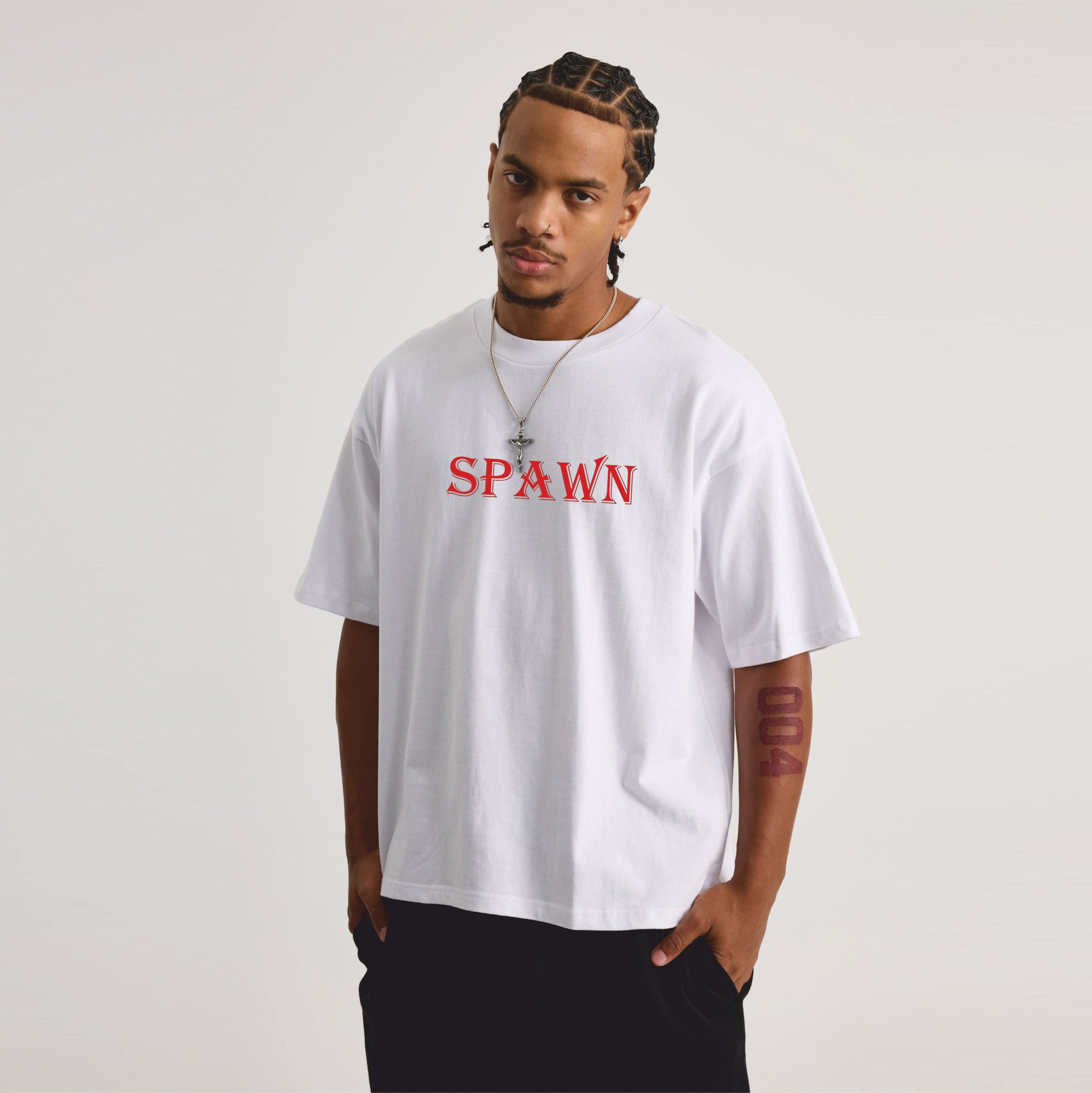 Person wearing a white t-shirt with 'SPAWN' printed in red on a plain background