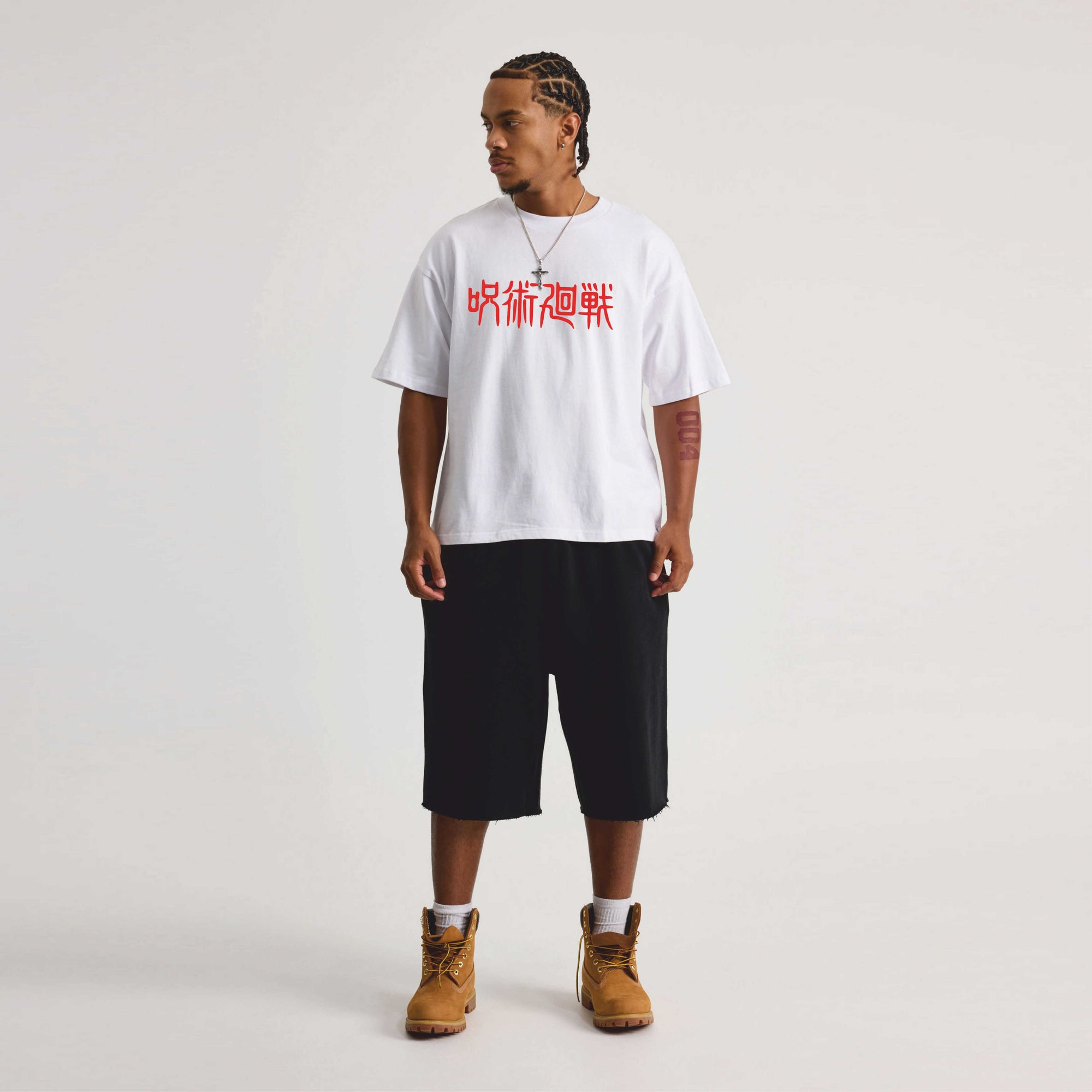 Person wearing a white t-shirt with red jujutsu  text, black shorts.