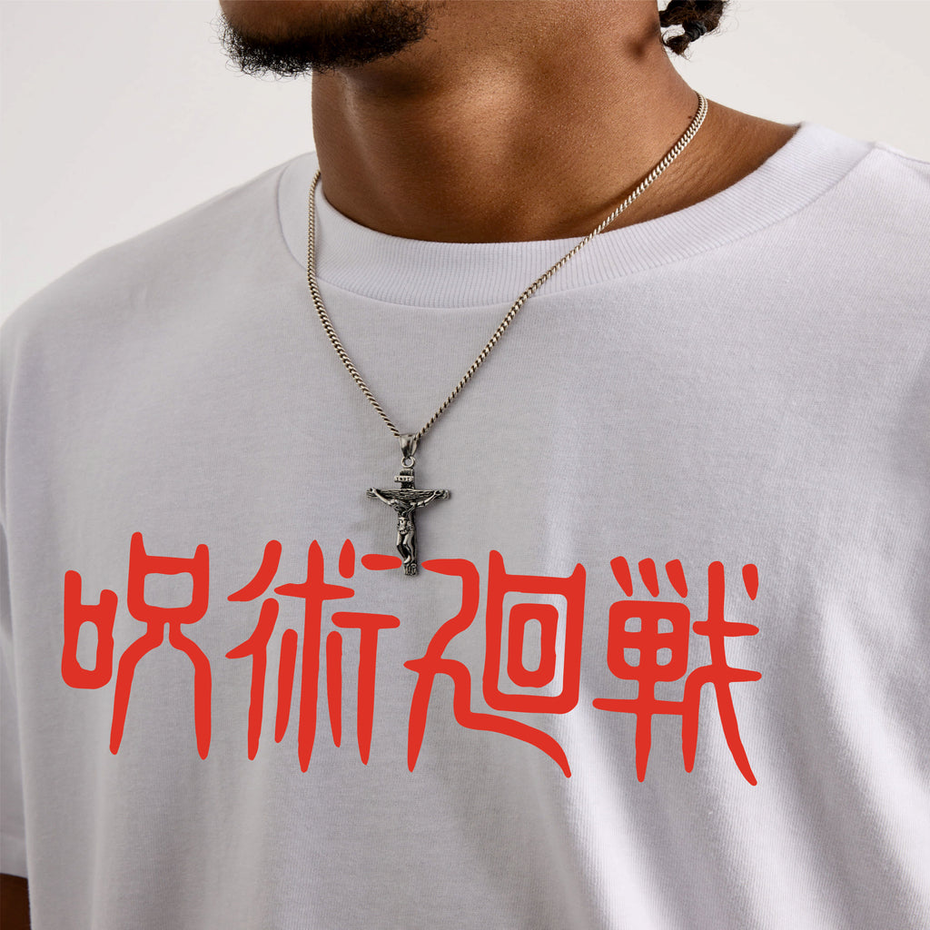 Person wearing a white t-shirt with red jujutsu Kaisen text and a necklace with a cross pendant.