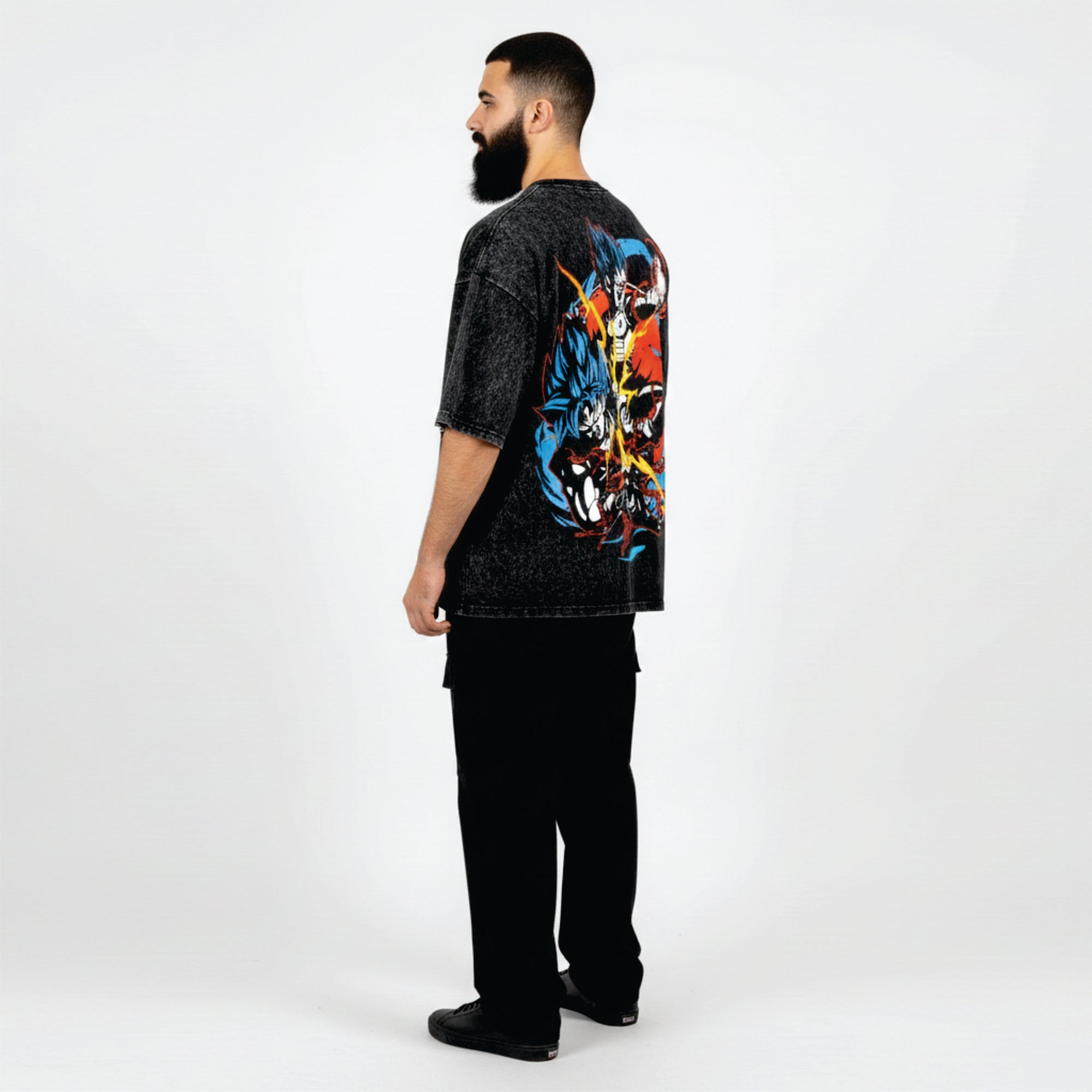 Man wearing a black t-shirt with colorful graphic design on the back, standing against a white background