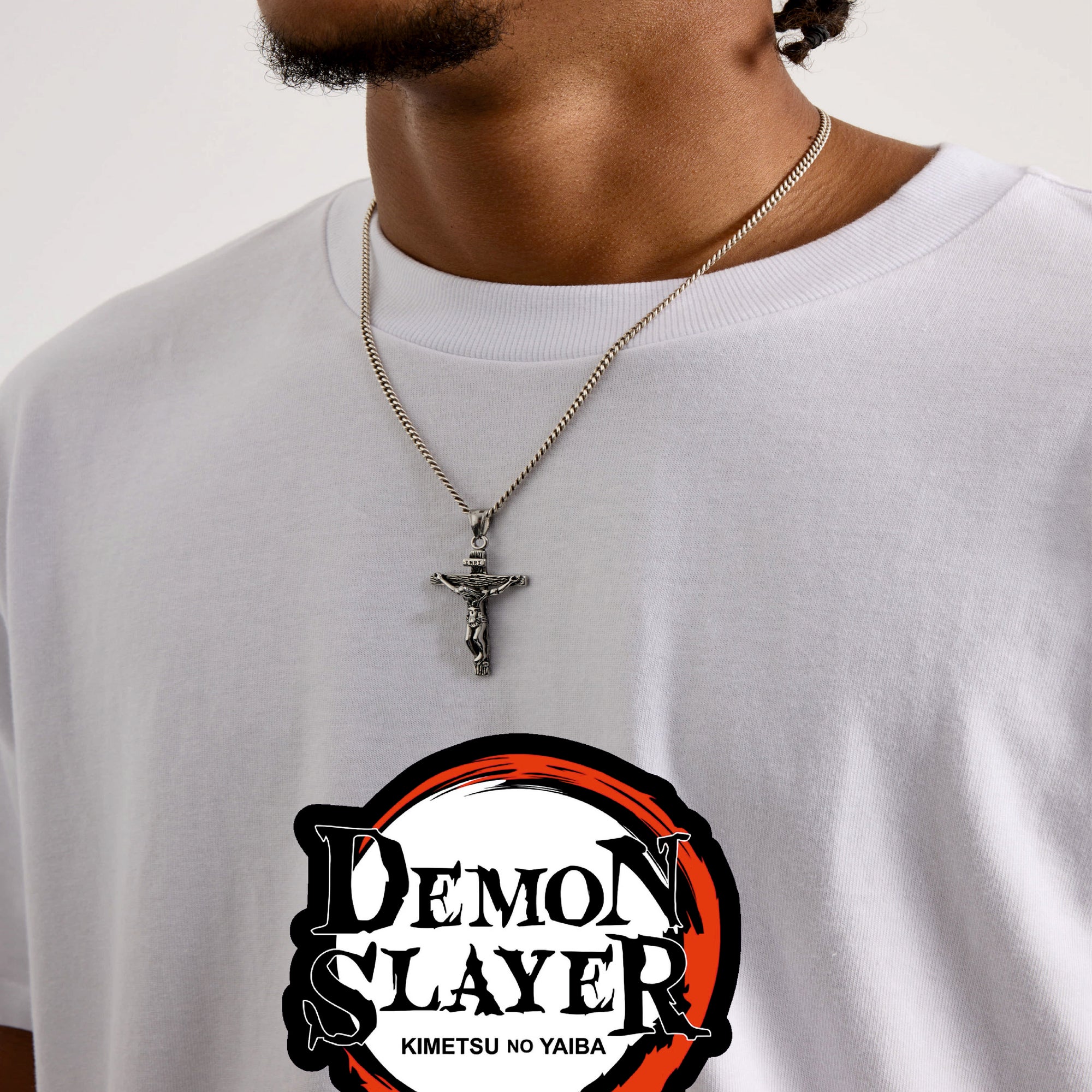Person wearing a white shirt with a 'Demon Slayer' logo and a necklace.
