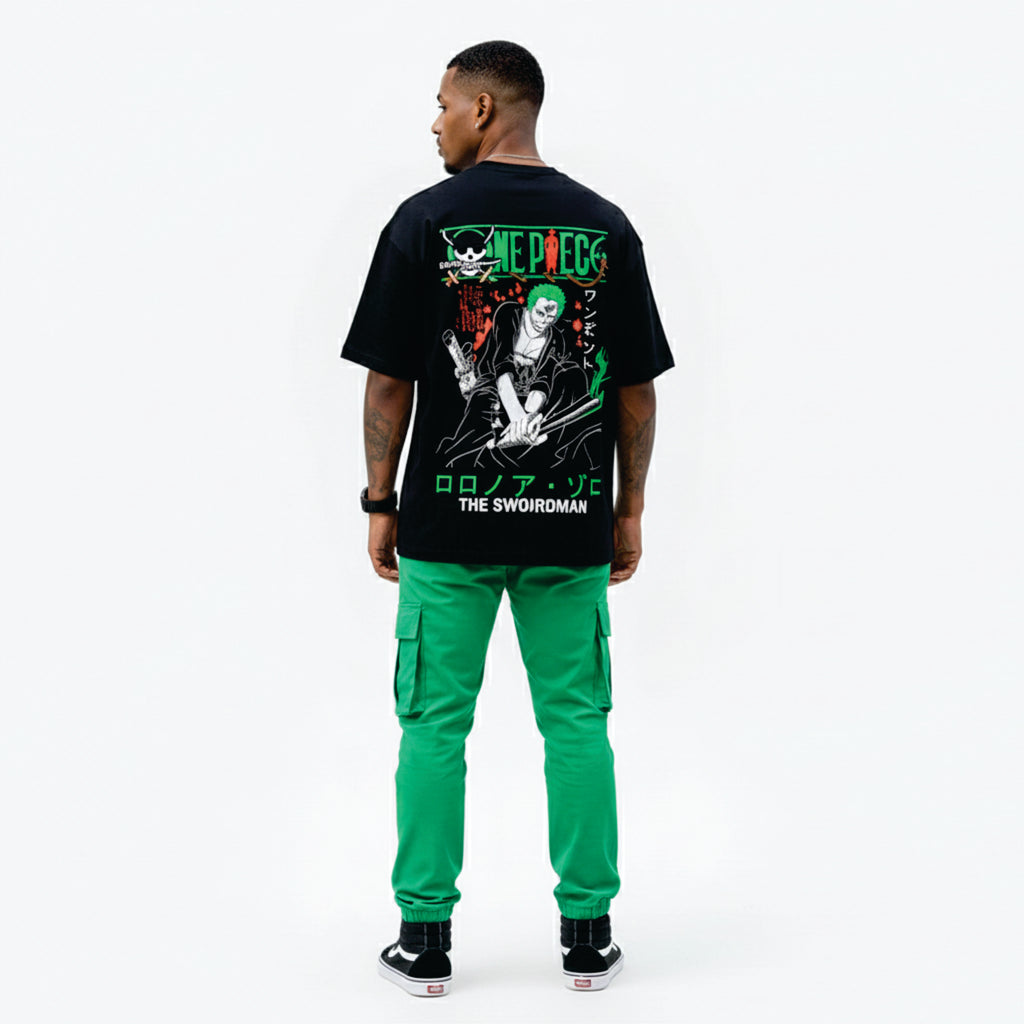 Person wearing a black t-shirt with graphic design and green pants on a white background