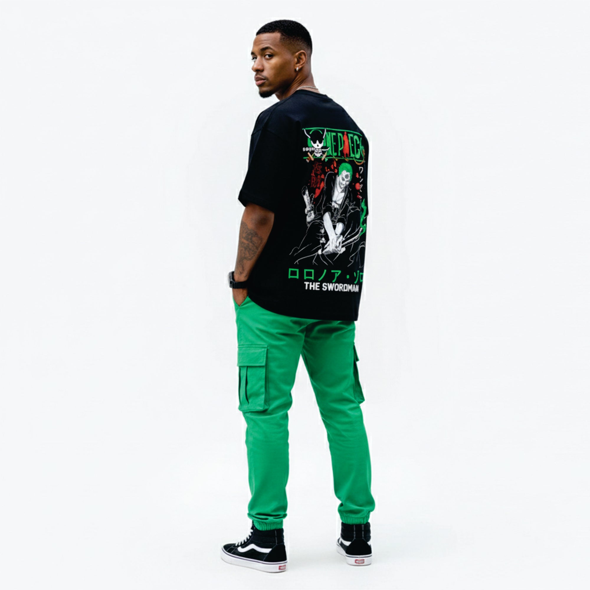Person wearing a black graphic t-shirt and bright green pants on a white background