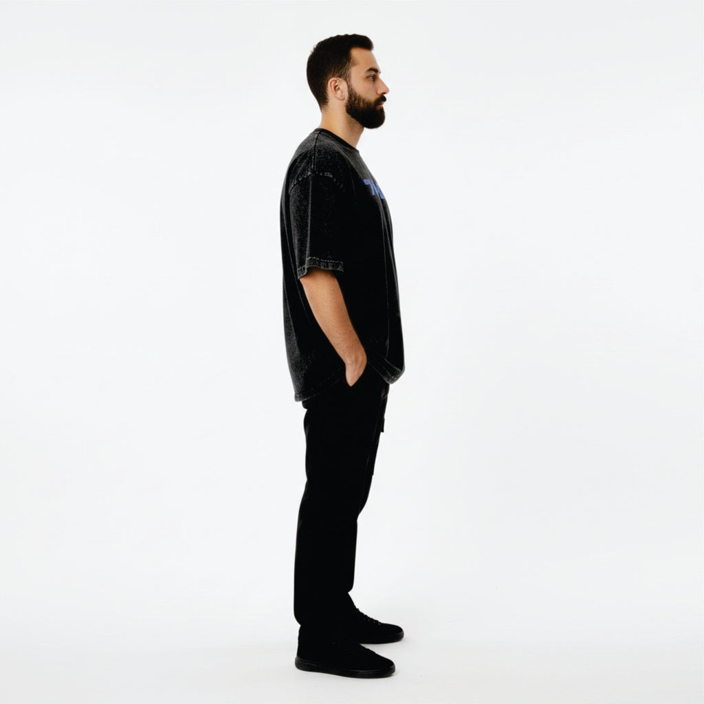 Man wearing a black outfit with a logo on a white background