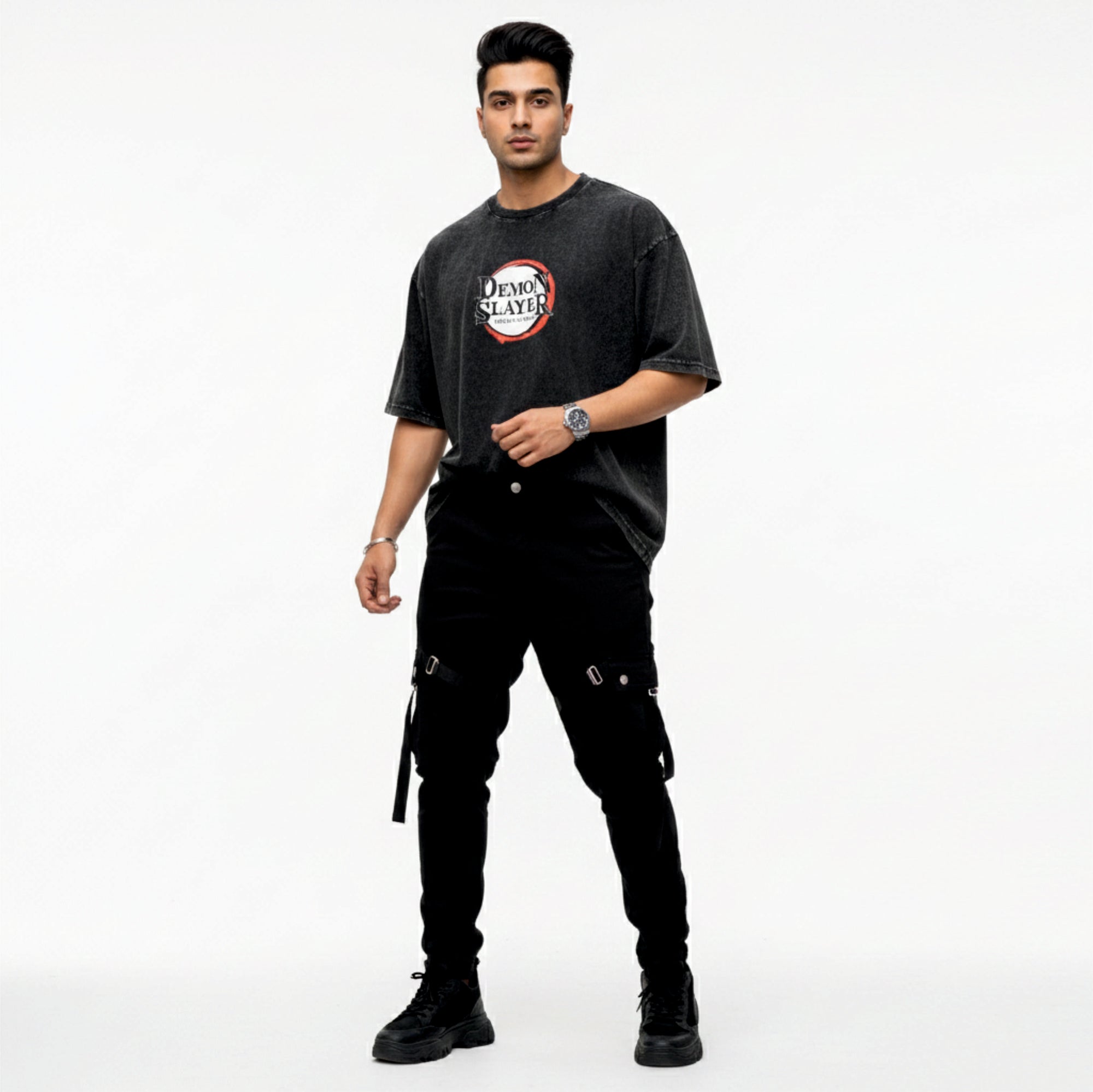 Man wearing a black t-shirt with a graphic design and black pants on a white background