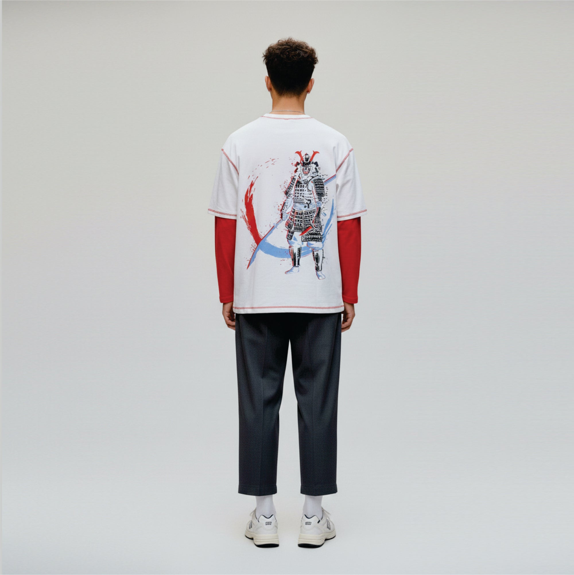 Person wearing a white t-shirt with a graphic design on a plain background