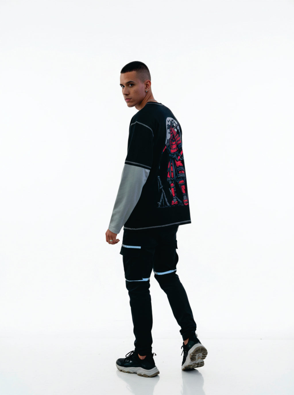 Person wearing a black and gray outfit with colorful designs on a white background