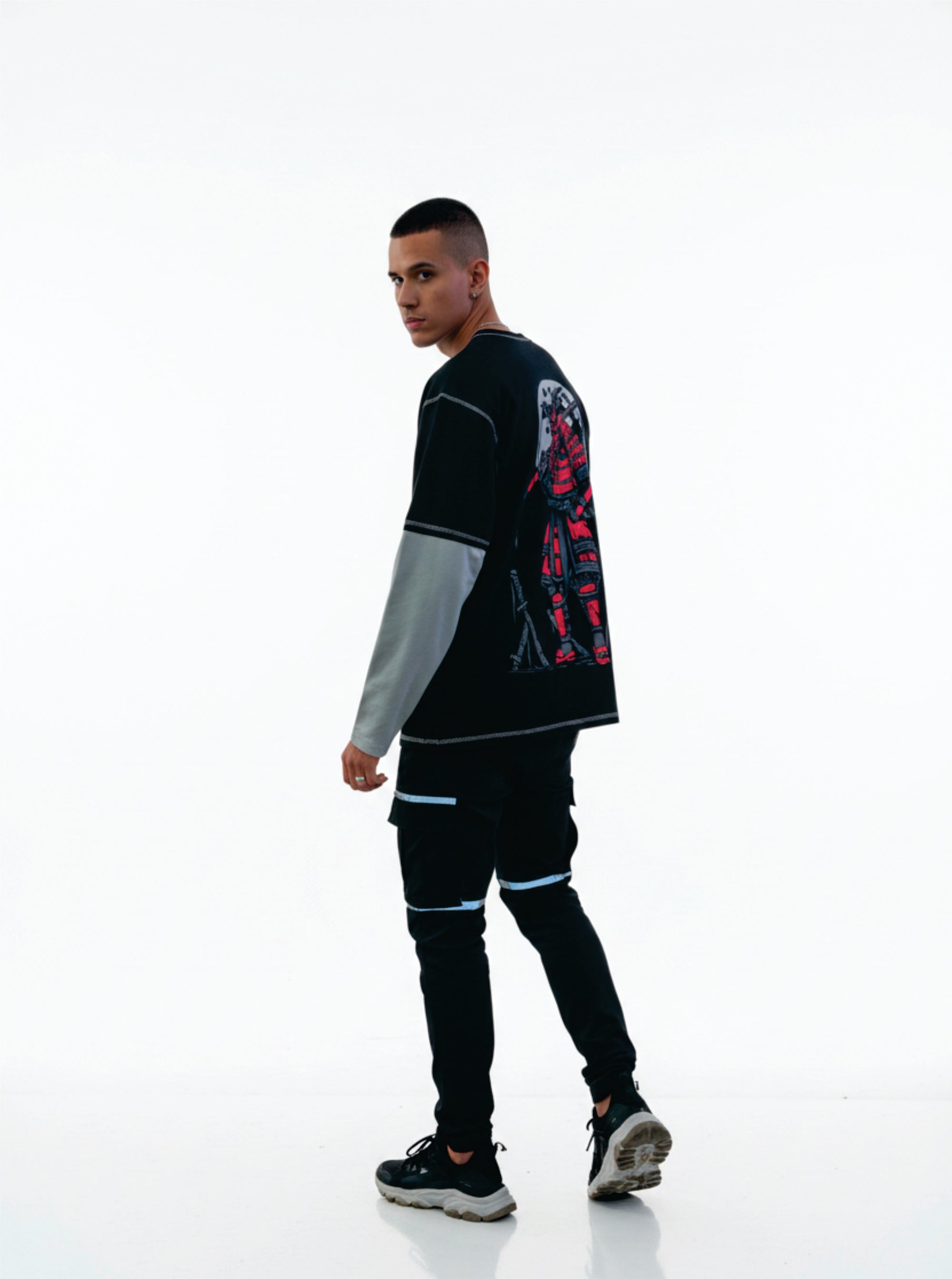 Person wearing a black and gray outfit with colorful designs on a white background