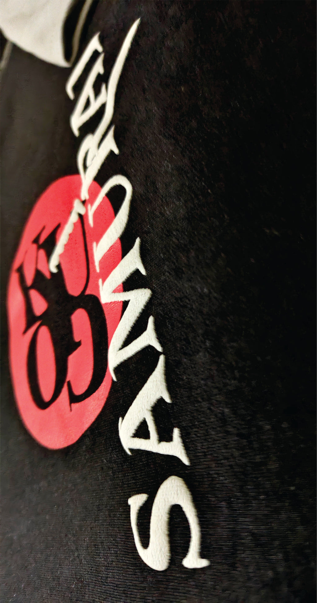 Black hoodie with a pink and white logo on a dark background