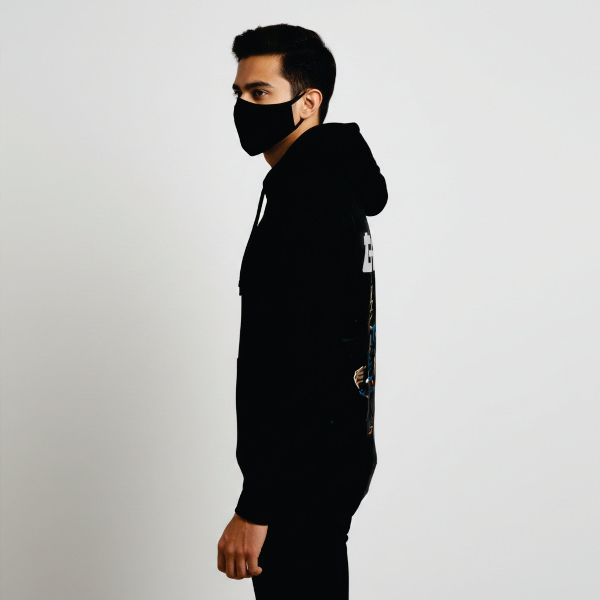 Person wearing a black hoodie and face mask on a light gray background