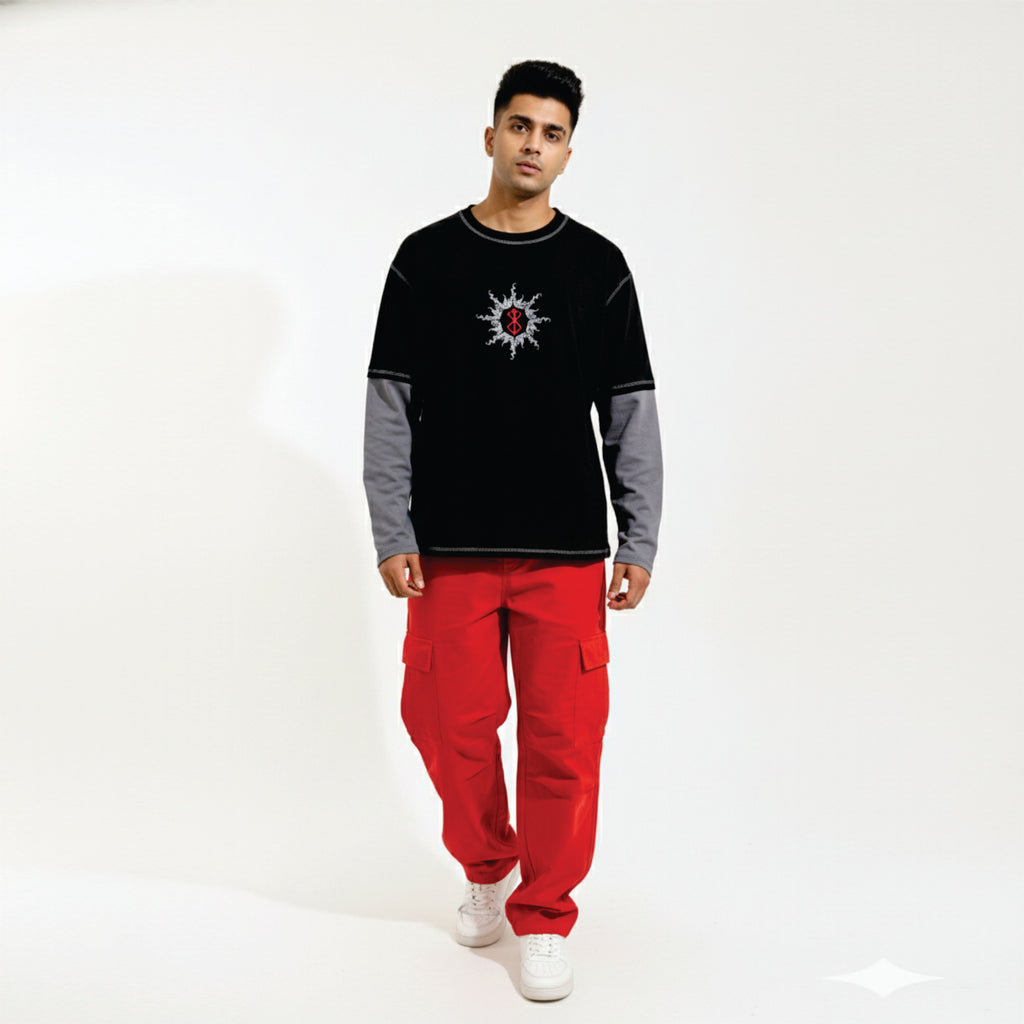 Man wearing a black and gray sweater with a red design and red pants on a white background