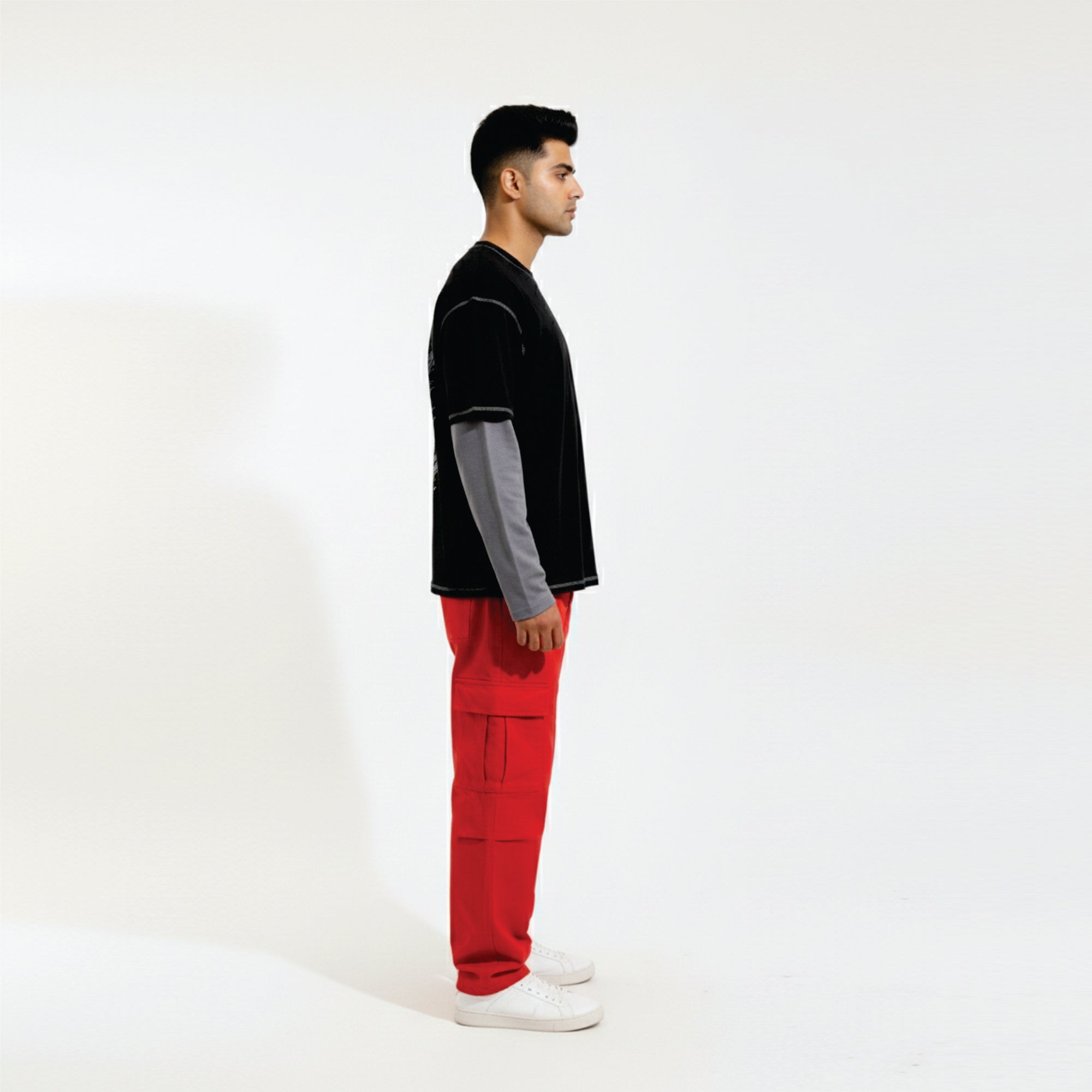 Person wearing a black and gray top with red pants on a white background