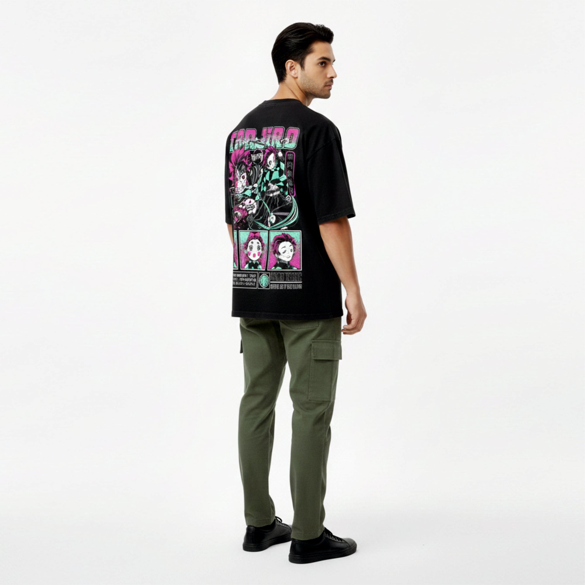 Man wearing a black t-shirt with colorful graphic design and green pants on a white background