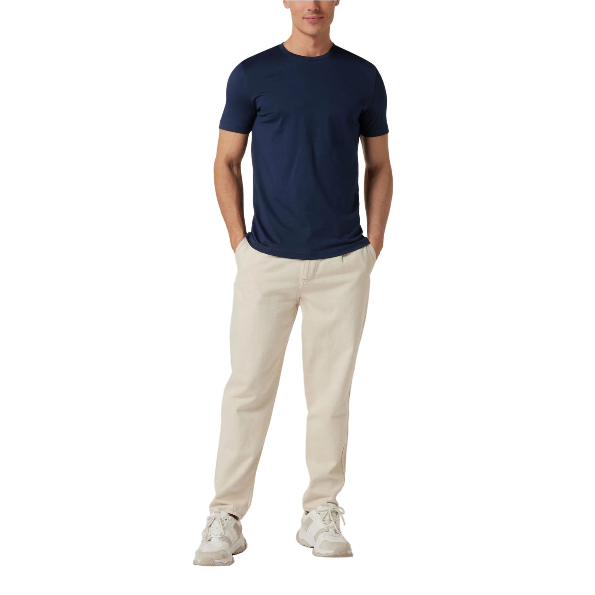 Person wearing a navy t-shirt and beige pants on a white background