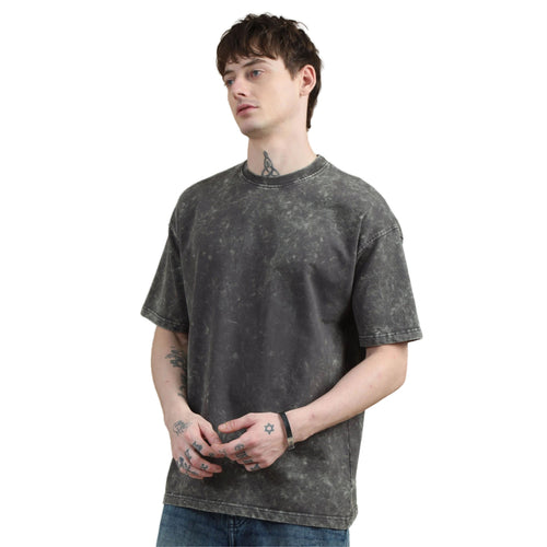 Person wearing a black acid-wash t-shirt on a white background