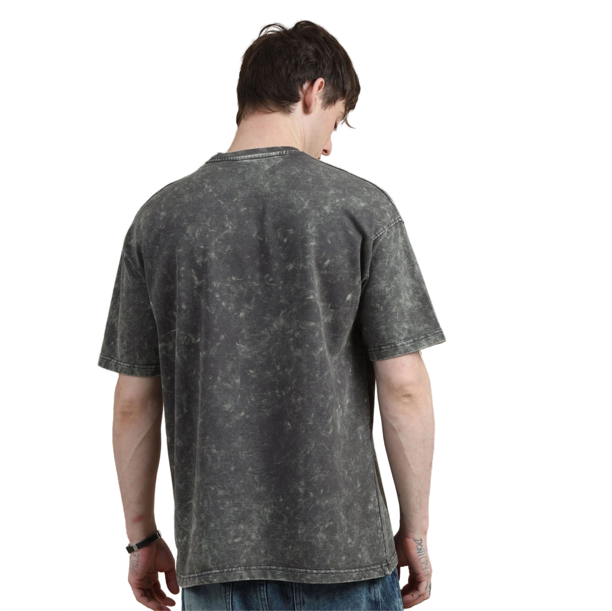 Person wearing a black acid-wash t-shirt on a white background