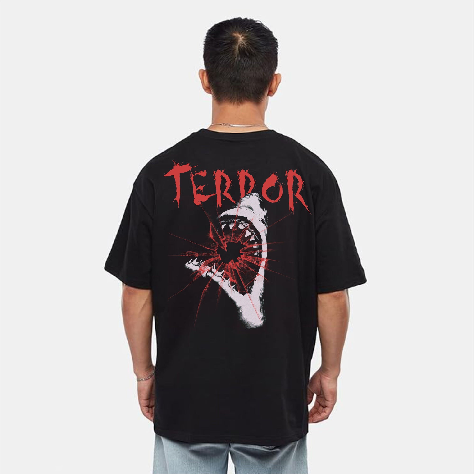 Person wearing a black t-shirt with 'TERROR' printed on the back against a white background