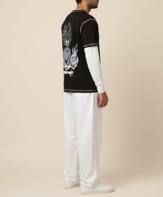 Person wearing a black and white outfit with a visible brand logo on a beige background