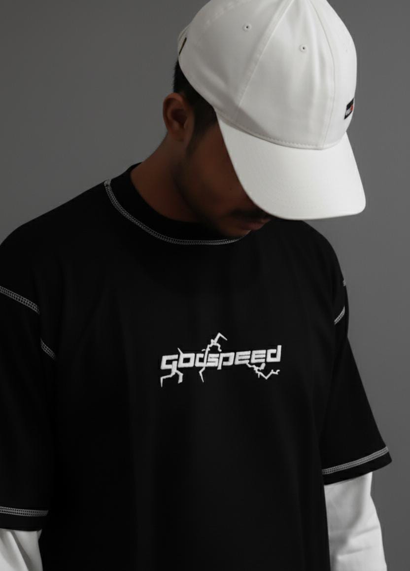 Person wearing a black t-shirt with 'Godspeed' logo and a white cap on a dark background